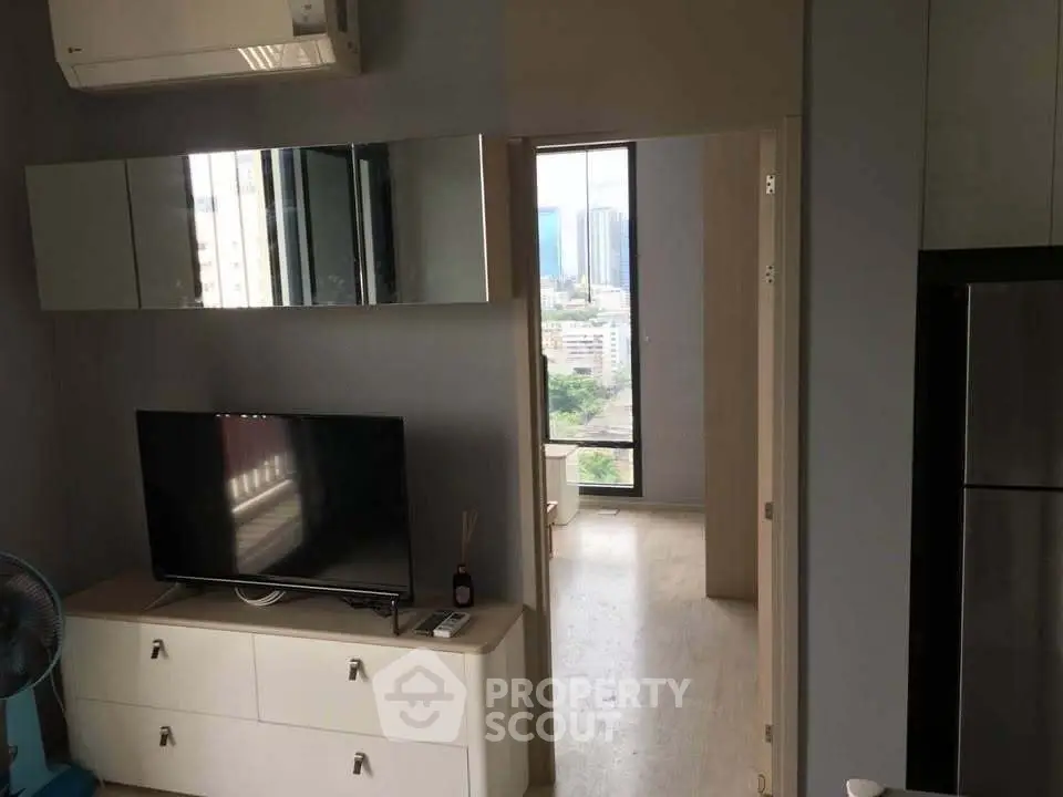 Modern apartment interior with TV and city view from window