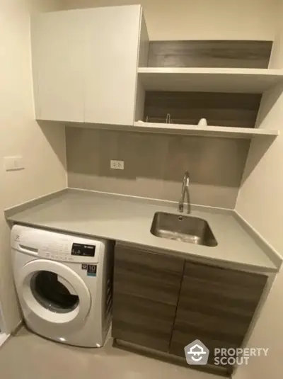 Modern laundry room with washing machine and sleek cabinetry