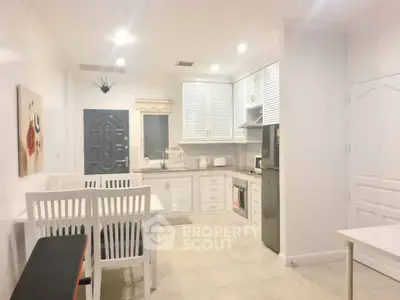 Charming kitchen with white cabinetry and dining area, perfect for cozy meals.