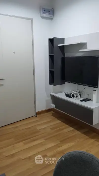 Modern living room with sleek TV setup and wooden flooring