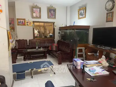 Cozy living room with traditional wooden furniture and large fish tank, perfect for relaxation.