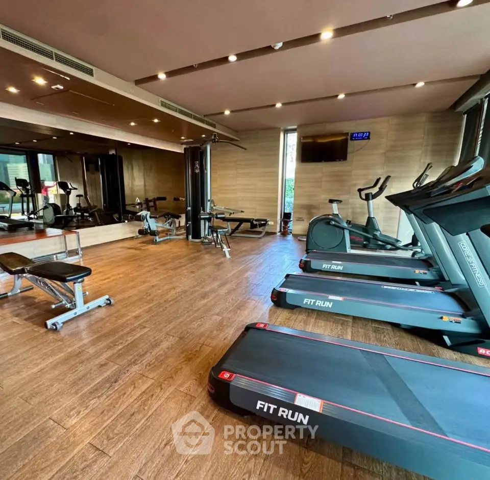 Modern gym with treadmills and fitness equipment in luxury residential building.