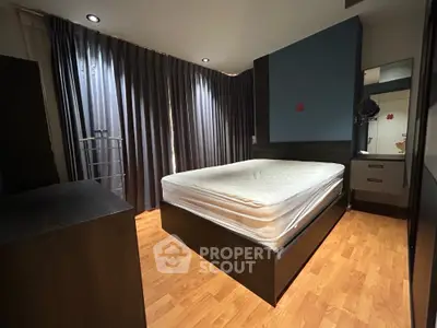 Spacious bedroom with modern furnishings and large windows for natural light.