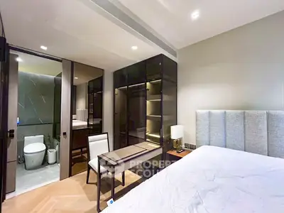 Luxurious bedroom with ensuite bathroom and modern furnishings in a stylish apartment.