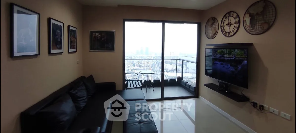 Modern living room with city view and balcony access, featuring sleek black furniture and wall art.
