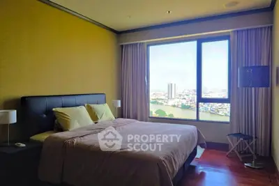 Spacious bedroom with large window offering stunning city view, perfect for relaxation and comfort.