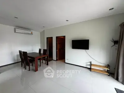 Spacious modern living room with dining area and wall-mounted TV, featuring sleek white tiles and minimalist decor.