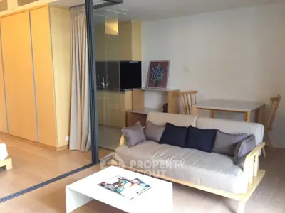 Modern living room with open kitchen and stylish furniture in a cozy apartment.