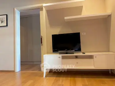 Modern living room with wooden flooring and sleek TV stand, perfect for cozy evenings.
