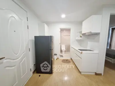 Compact kitchen with modern appliances and adjacent bathroom in cozy apartment