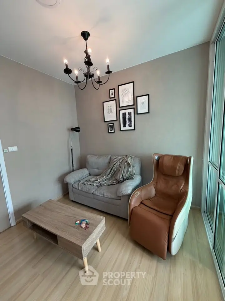 Cozy living room with modern chandelier, comfortable sofa, and massage chair, perfect for relaxation.