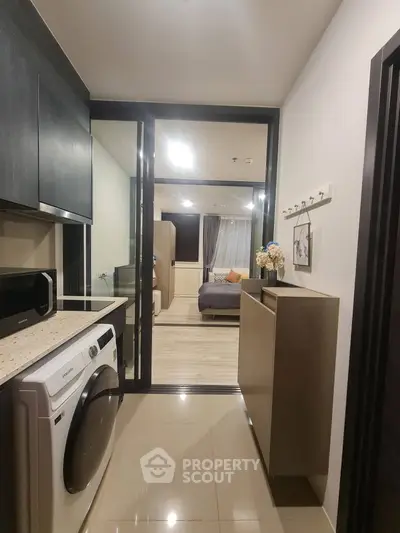 Modern apartment interior with sleek kitchen and cozy bedroom view.