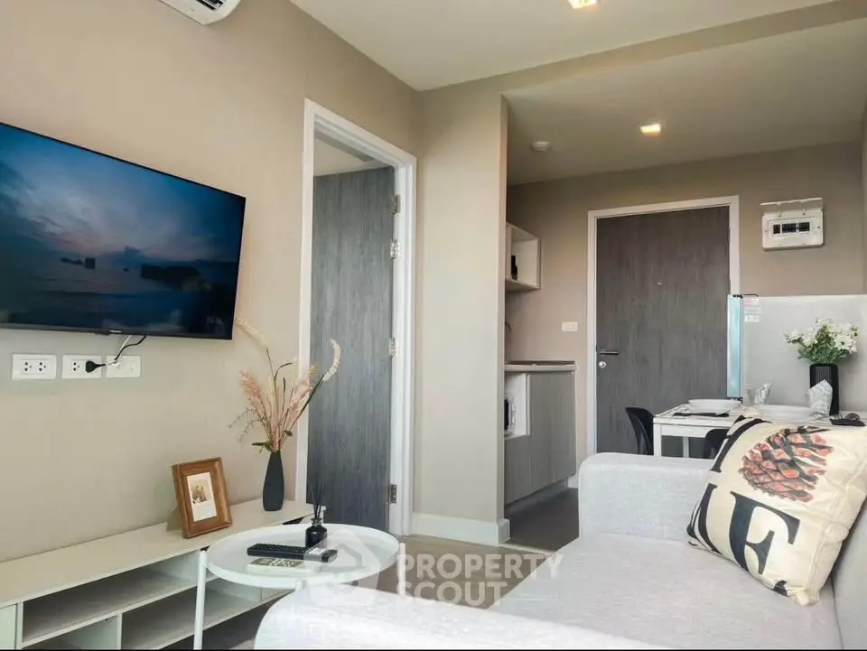 Modern living room with stylish decor and wall-mounted TV in a cozy apartment.