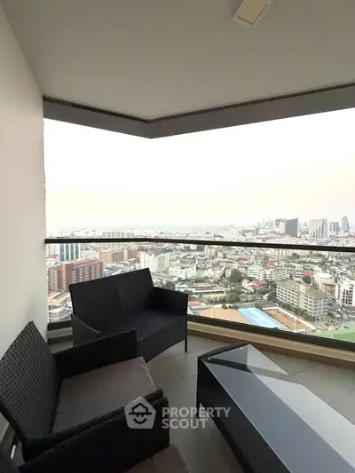 Stunning cityscape view from a modern balcony with stylish outdoor seating.