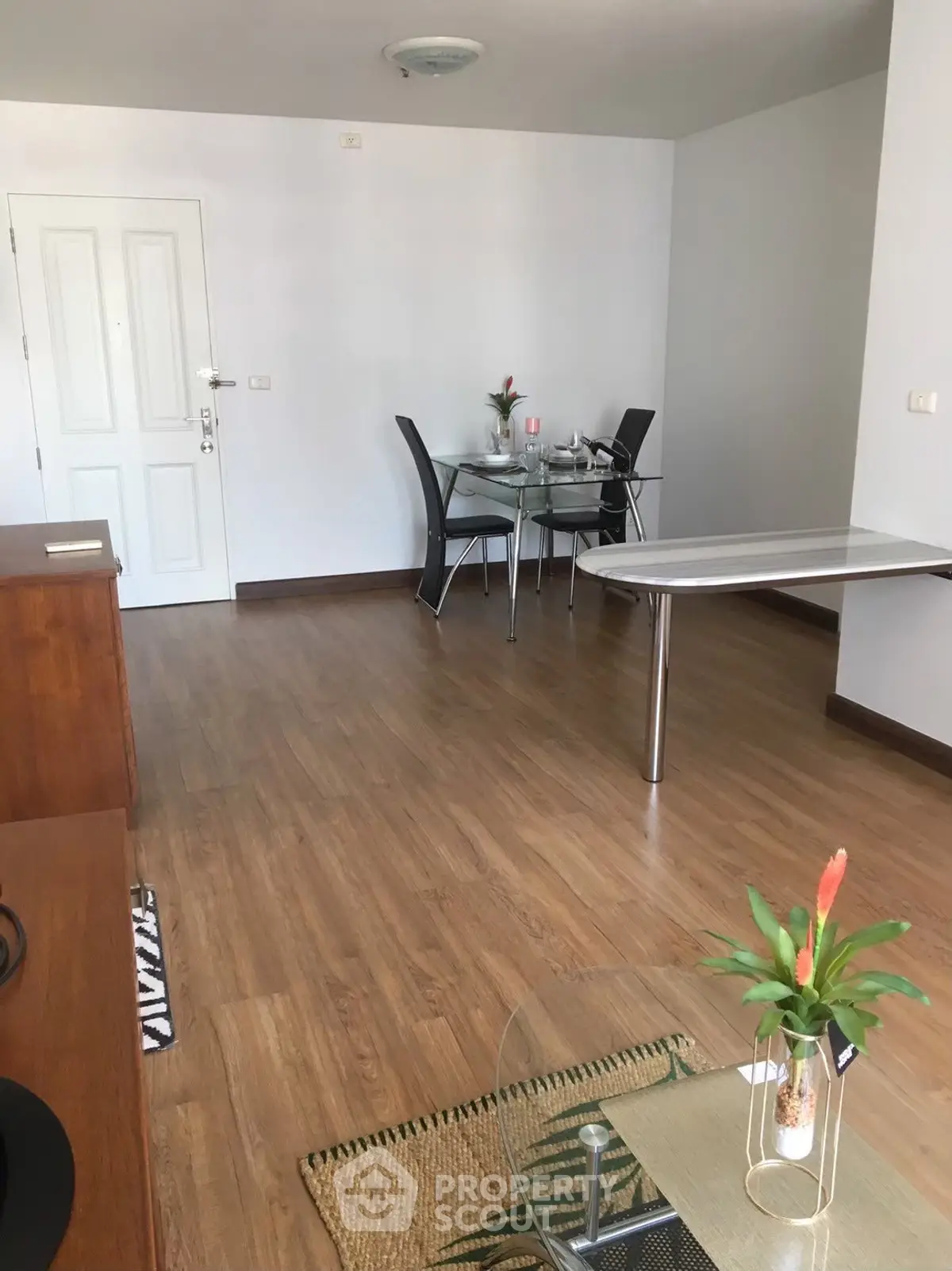 Spacious living room with modern dining area and elegant wooden flooring.
