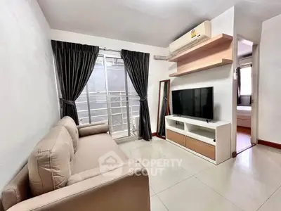 Modern living room with sleek furniture and natural light, featuring a cozy sofa and flat-screen TV.