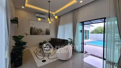 Luxurious living room with pool view, modern decor, and elegant lighting