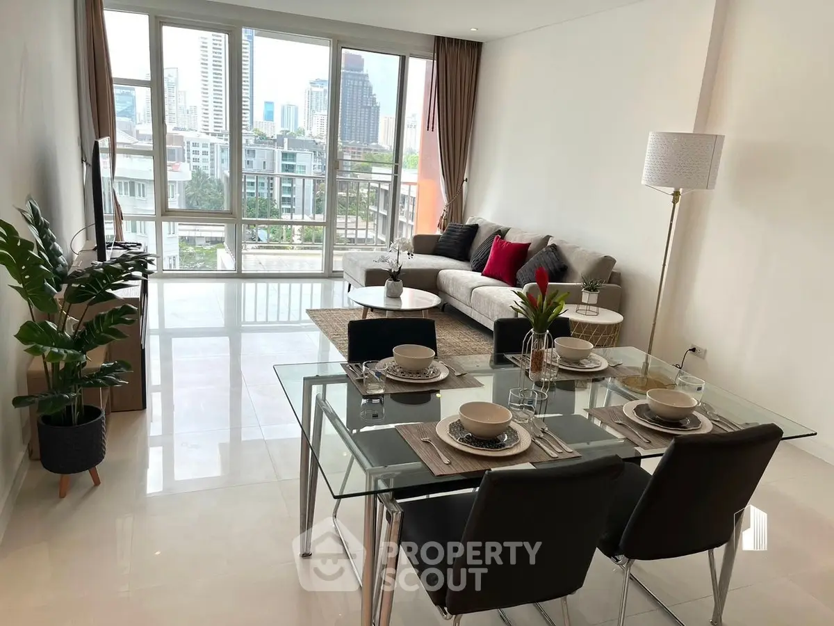 Modern living room with city view, elegant dining setup, and cozy seating area.