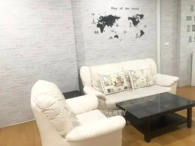 Cozy living room with white sofas and world map wall decor