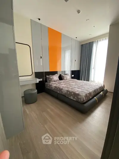 Modern bedroom with stylish decor and large window for natural light