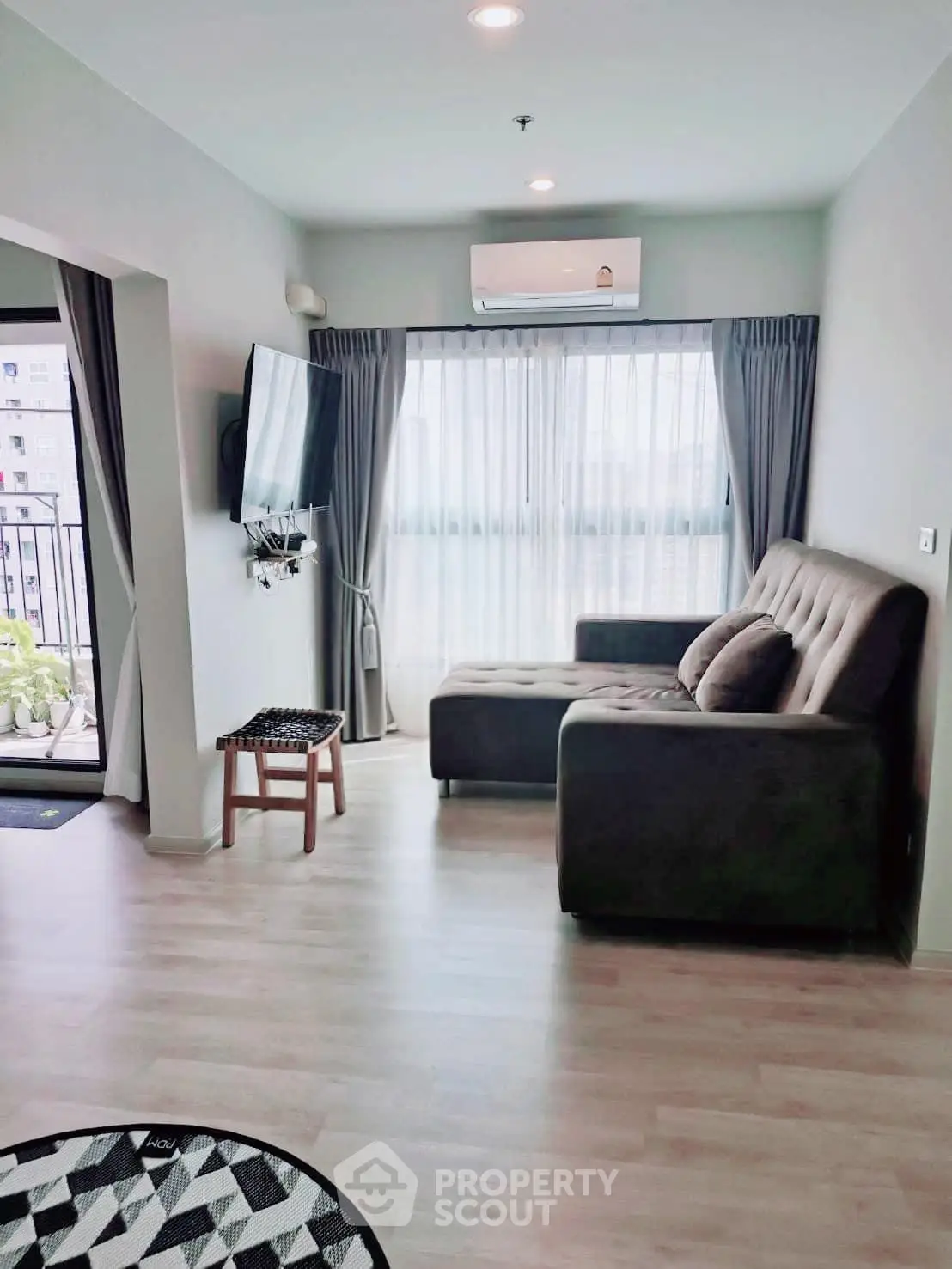 Modern living room with large windows and balcony access in a stylish apartment.