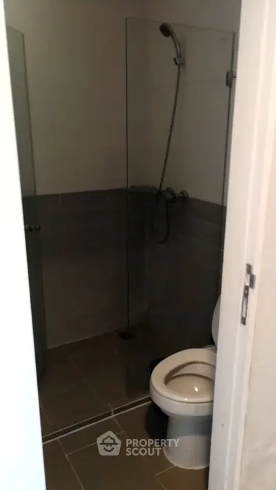Compact bathroom with glass shower enclosure and modern fixtures.