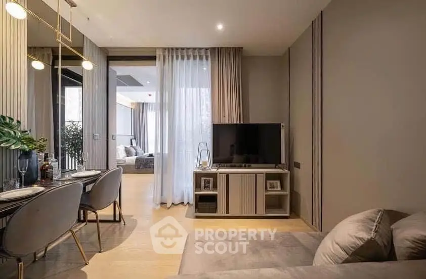 Modern living room with elegant decor and open layout leading to a cozy bedroom.