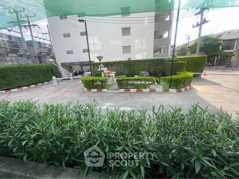 Spacious parking area with lush greenery in a modern residential complex.