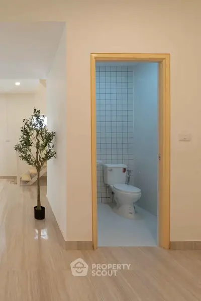 Modern interior with wooden flooring and small bathroom, ideal for compact living spaces.