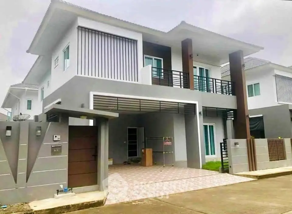 Modern two-story house with sleek design and spacious driveway in a suburban neighborhood.