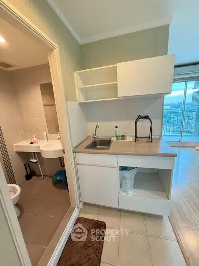 Compact kitchen with open layout and adjacent bathroom in modern apartment