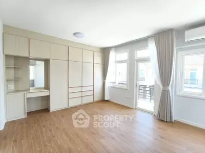 Spacious bedroom with built-in wardrobe and large windows for natural light