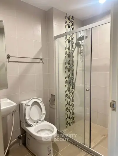 Modern bathroom with glass shower enclosure and stylish tile accents