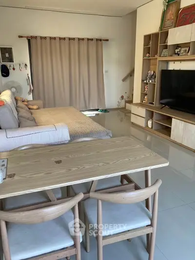 Spacious living room with modern decor and large TV, perfect for relaxation and entertainment.