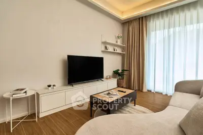 Modern living room with sleek TV setup and cozy seating area, perfect for relaxation.