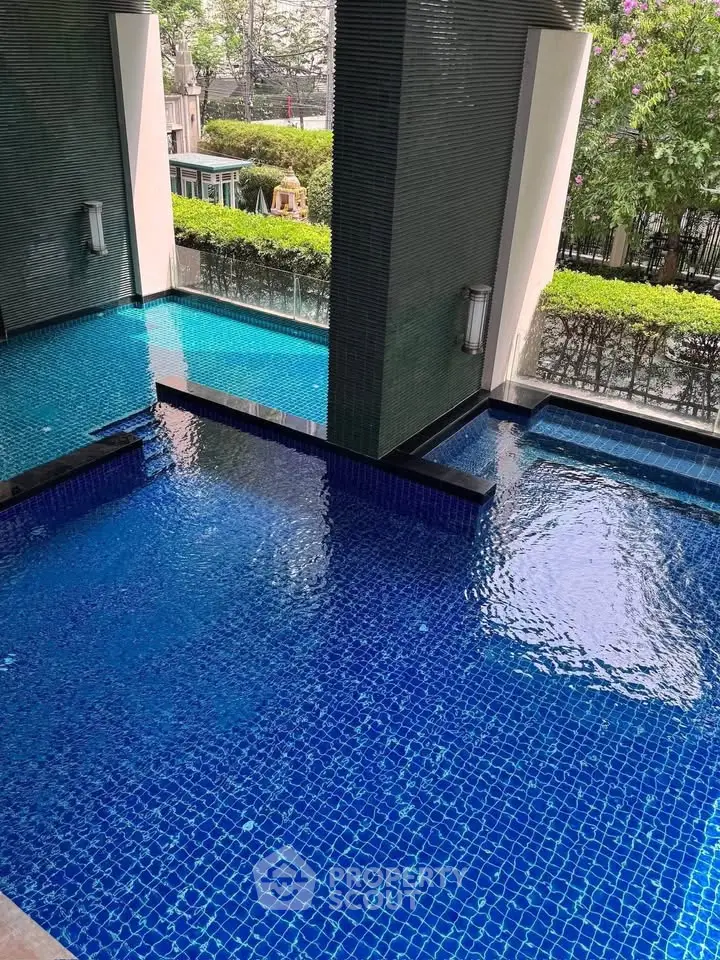 Luxurious residential pool area with modern design and lush greenery, perfect for relaxation and leisure.