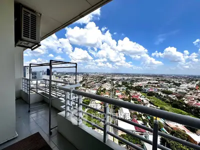 Stunning high-rise balcony view overlooking cityscape with clear blue skies.
