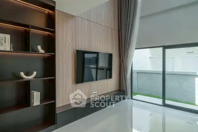 Modern living room with sleek TV setup and large window for natural light