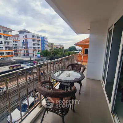 Spacious balcony with city view and outdoor seating in modern apartment