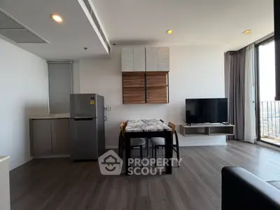 Modern living room with dining area and city view balcony in high-rise apartment.
