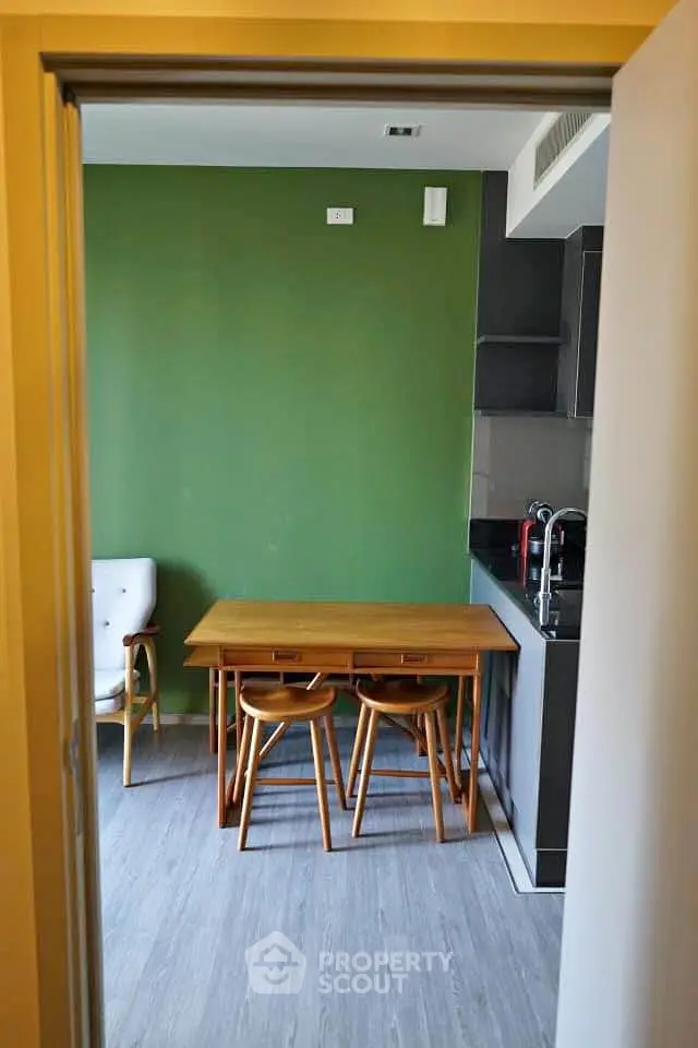 Modern kitchen with green accent wall and wooden dining set