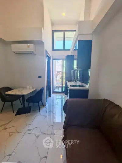 Modern living room with open kitchen and balcony view in luxury apartment