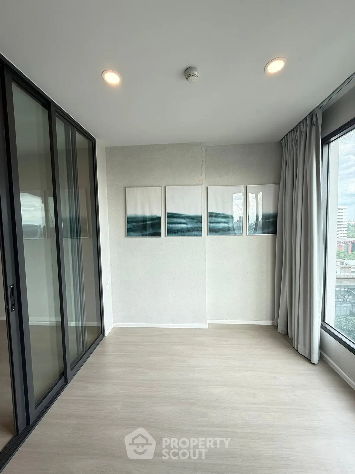 Spacious modern room with large windows and elegant decor in a high-rise building.