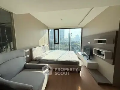 Modern bedroom with city view, featuring sleek furniture and large windows.