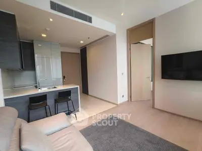 Modern open-plan living room with sleek kitchen and cozy seating area, perfect for urban living.