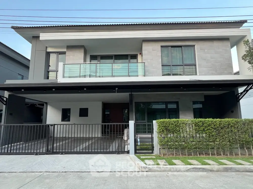 Modern two-story house with sleek design and spacious balcony in suburban neighborhood.