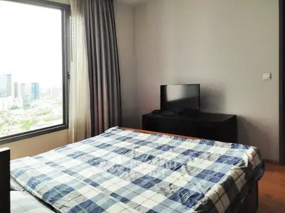 Cozy bedroom with city view, featuring a comfortable bed and a flat-screen TV, perfect for relaxation.