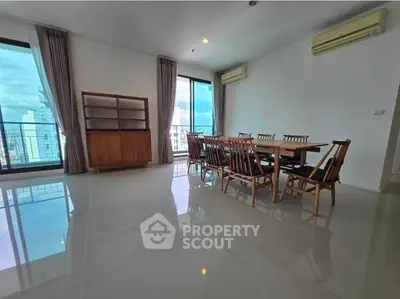 Spacious dining area with city view, featuring elegant wooden furniture and large windows for natural light.