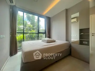 Modern bedroom with large window and lush greenery view, featuring minimalist design and natural light.