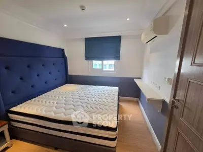 Cozy bedroom with modern design, featuring a comfortable bed and air conditioning, perfect for restful nights.
